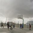 Michele Palazzi. Mongolia, Gobi, Tsogttsestiie sum, 2012. Some young boys are playing in the only public place of the village: the basketball field of the public school.
