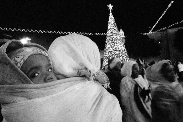 Linda Dorigo. West Bank, Bethlehem, December 2012. On Christmas night, Ethiopians dance in the square in front of the Church of the Nativity in Bethlehem. They are prevented from entering the church. In the Holy Land, Christmas is celebrated four times: by Catholics on December the 25th, on January the 6th by Orthodox, by Greek Orthodox on January the 13th, then on January the 21th by the Armenians.