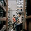 Valentino Bellini. Old Seelampur, New Delhi, India. Two young men during a break in a warehouse full of old cathode ray tube monitors. These types of devices contain polluting and toxic substances like lead, cadmium, hexavalent chromium and Brominated Flame Retardants (BFRs).