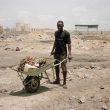Valentino Bellini. Agbogbloshie, Accra, Ghana. A young man is transporting electric materials that are highly toxic, ready to be burnt.